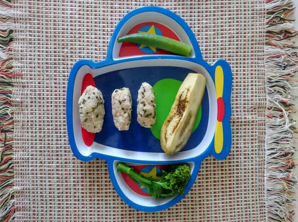 Prato infantil em formato de avião com bolinhos de arroz, berinjela, quiabo e brócolis